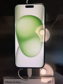 iPhone 15 Plus, önden, vitrinde açılış ekranı