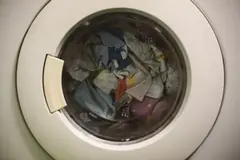 Çamaşır makinesinin kapağından görünen tambur ve çamaşırlar