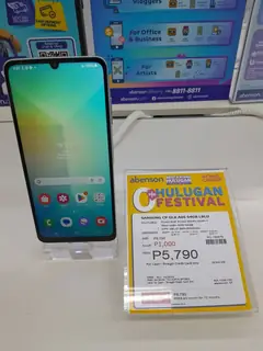Samsung Galaxy A06, önden, mağaza standında fiyat etiketiyle (açık mavi)